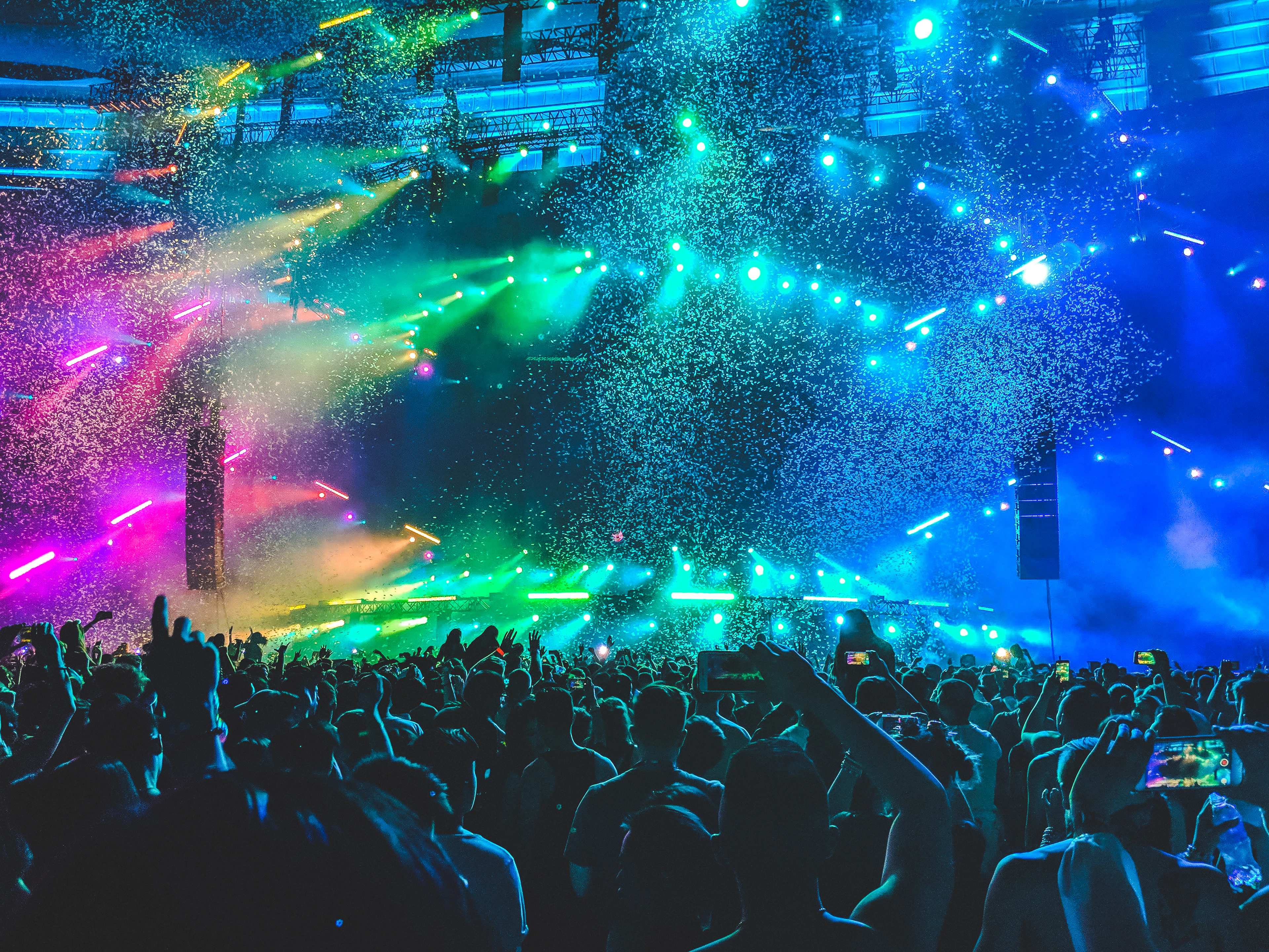 A wide frame of a crowd with stage lights above them