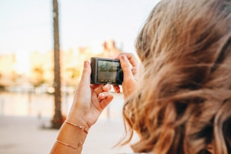 woman taking picture tree trunk