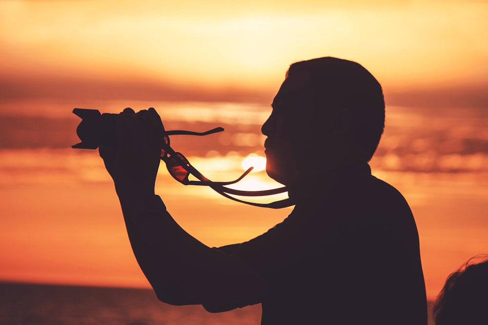 silhouette of man holding camera