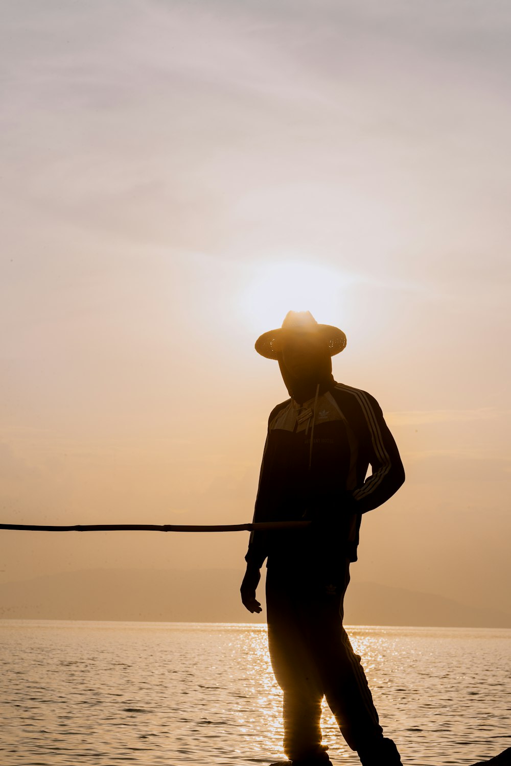 silhouette photo of person wearing sun hat during sunset