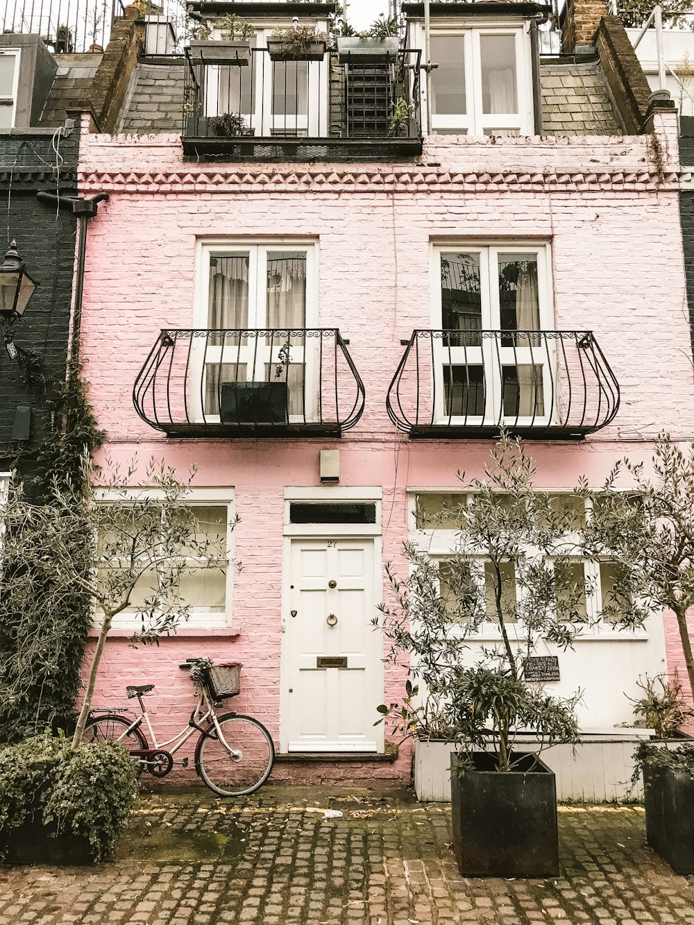 bicycle beside pink wall