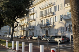 Modern residential buildings along a tree-lined urban street.