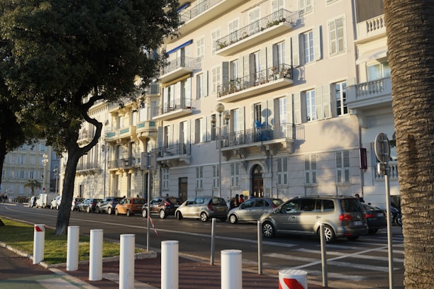 Modern residential buildings along a tree-lined urban street.