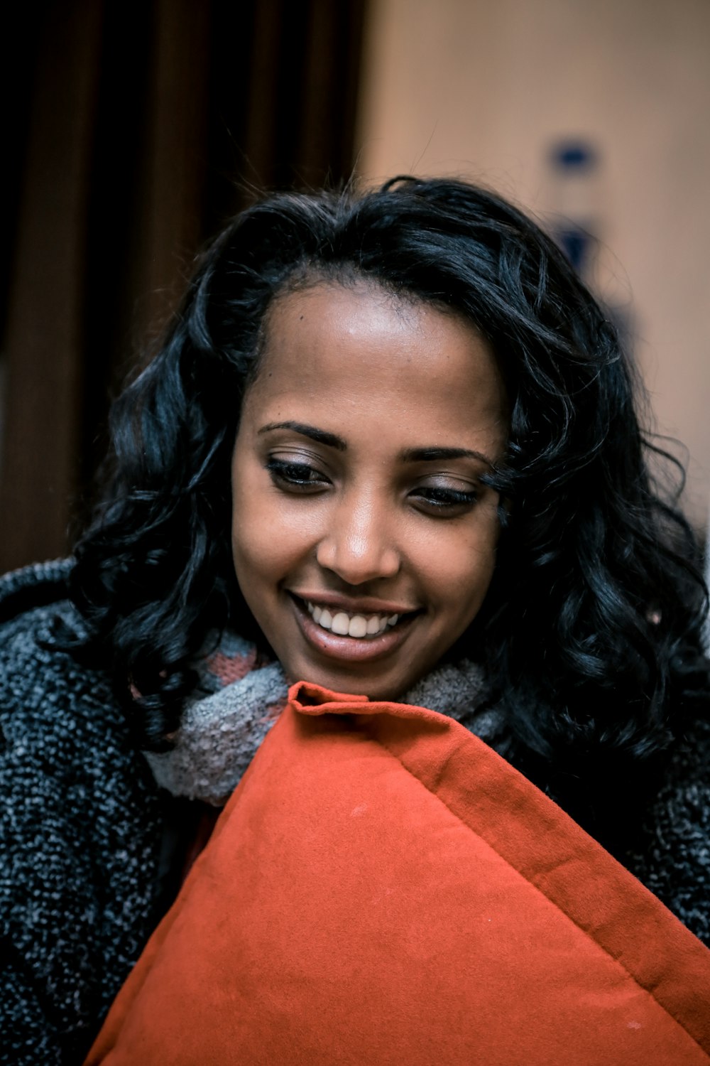 woman holding orange throw pillow