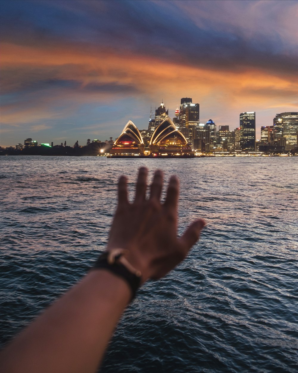 person left hand on body of water