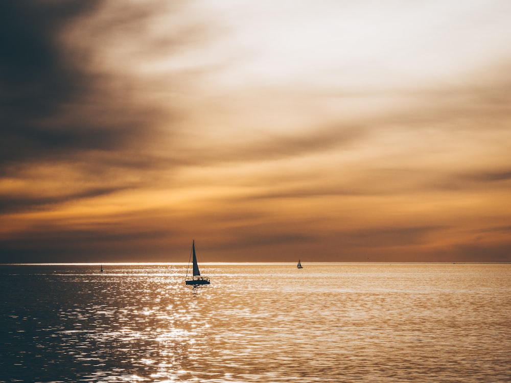 silhouette of sailboat sailing on the ocean