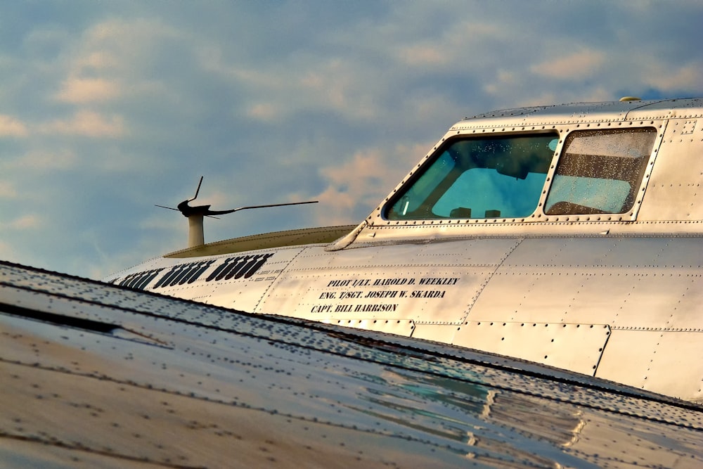 a propeller plane flying through a cloudy blue sky