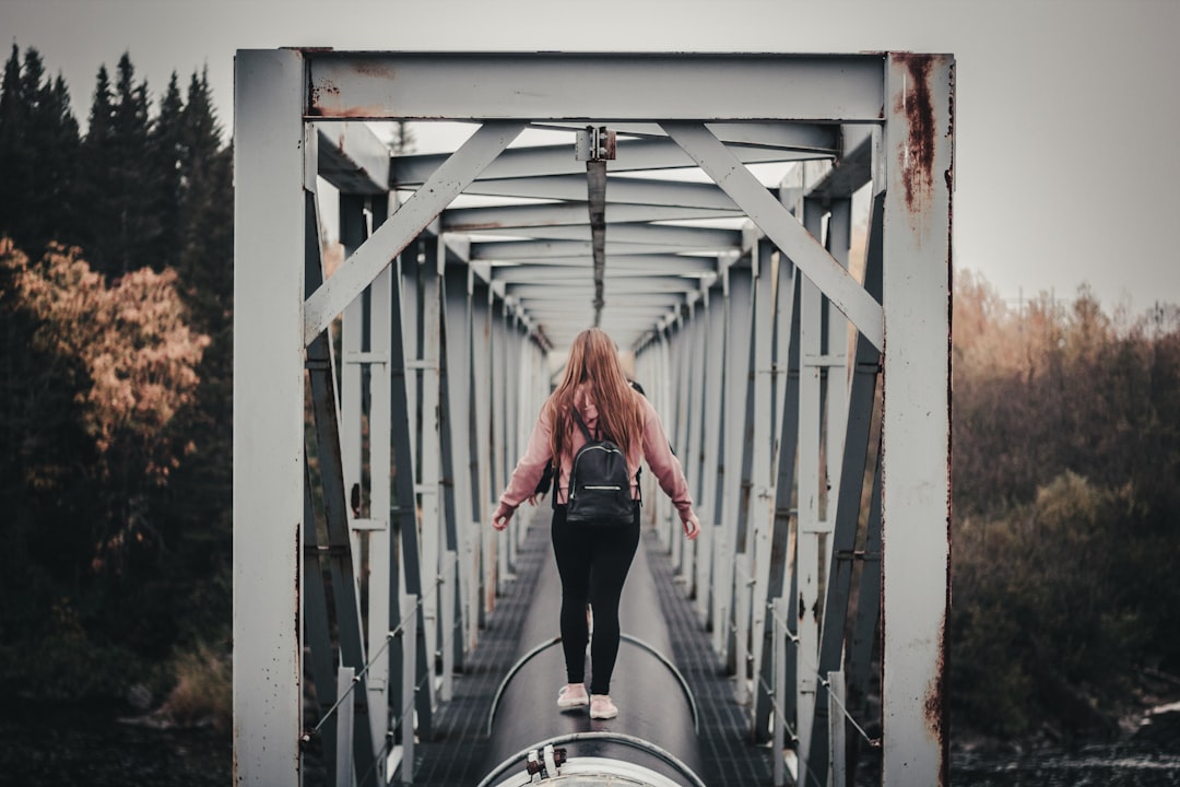 woman standing on black tunnel at daytime