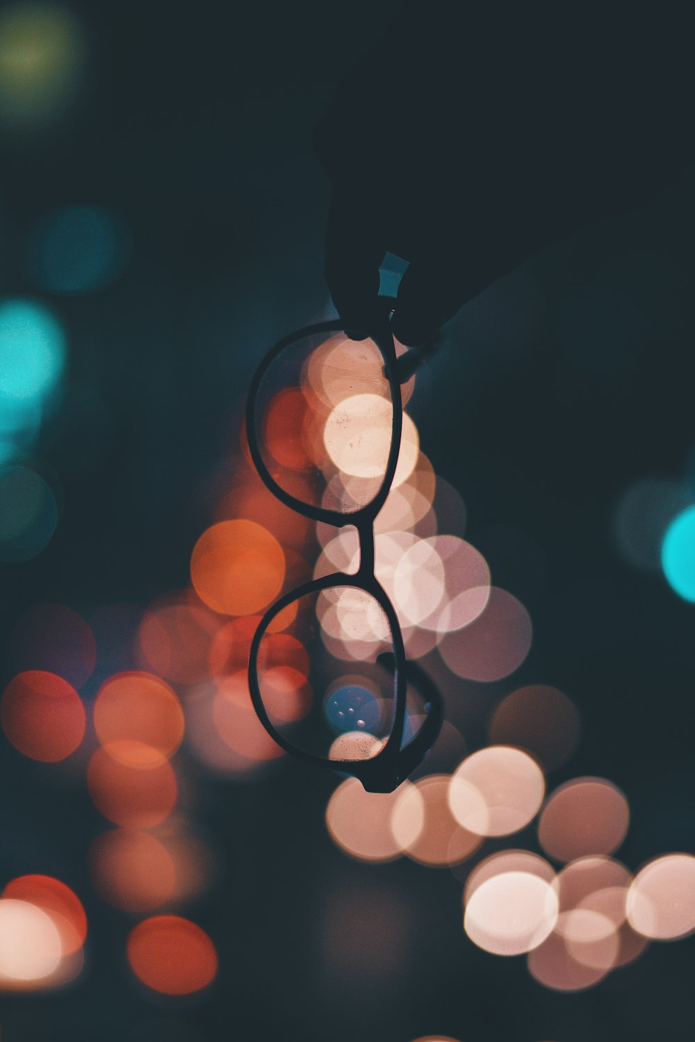 shallow focus photo of person holding eyeglasses