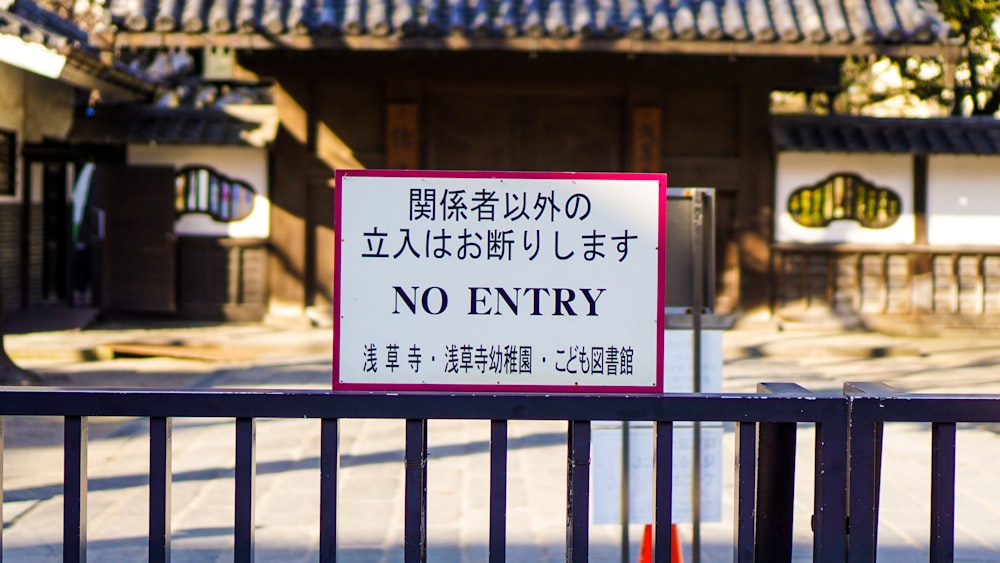 no entry sign on metal rail in front of building during day