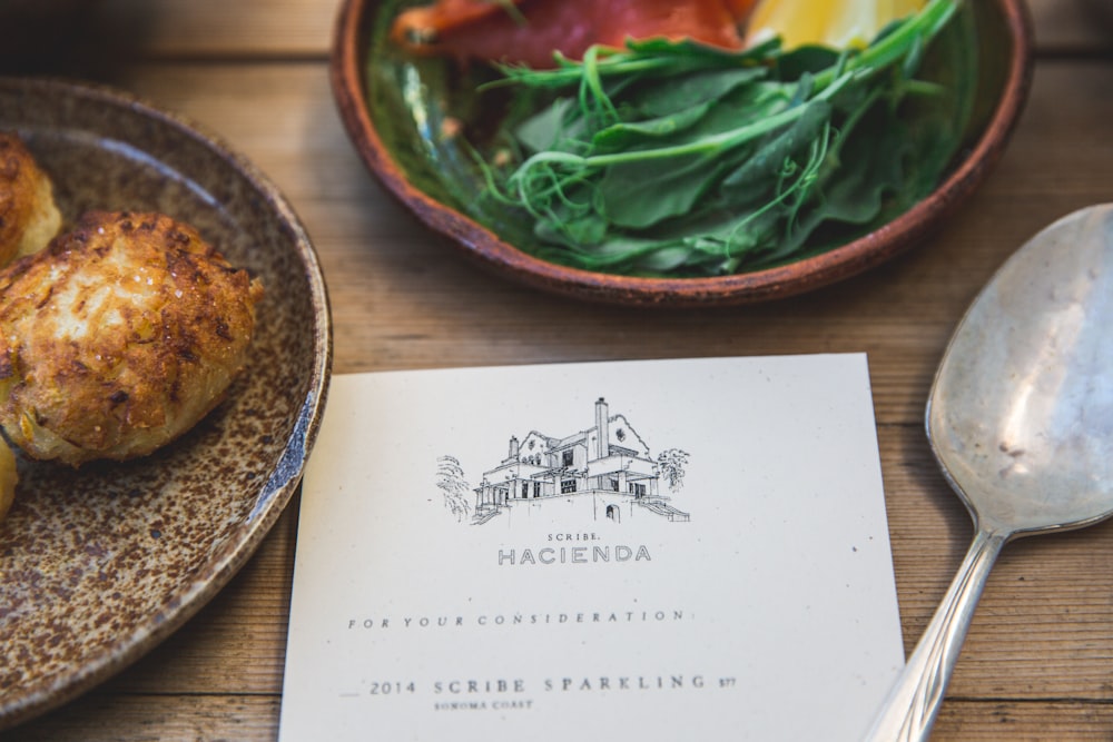 Hacienda book beside green vegetable on plate