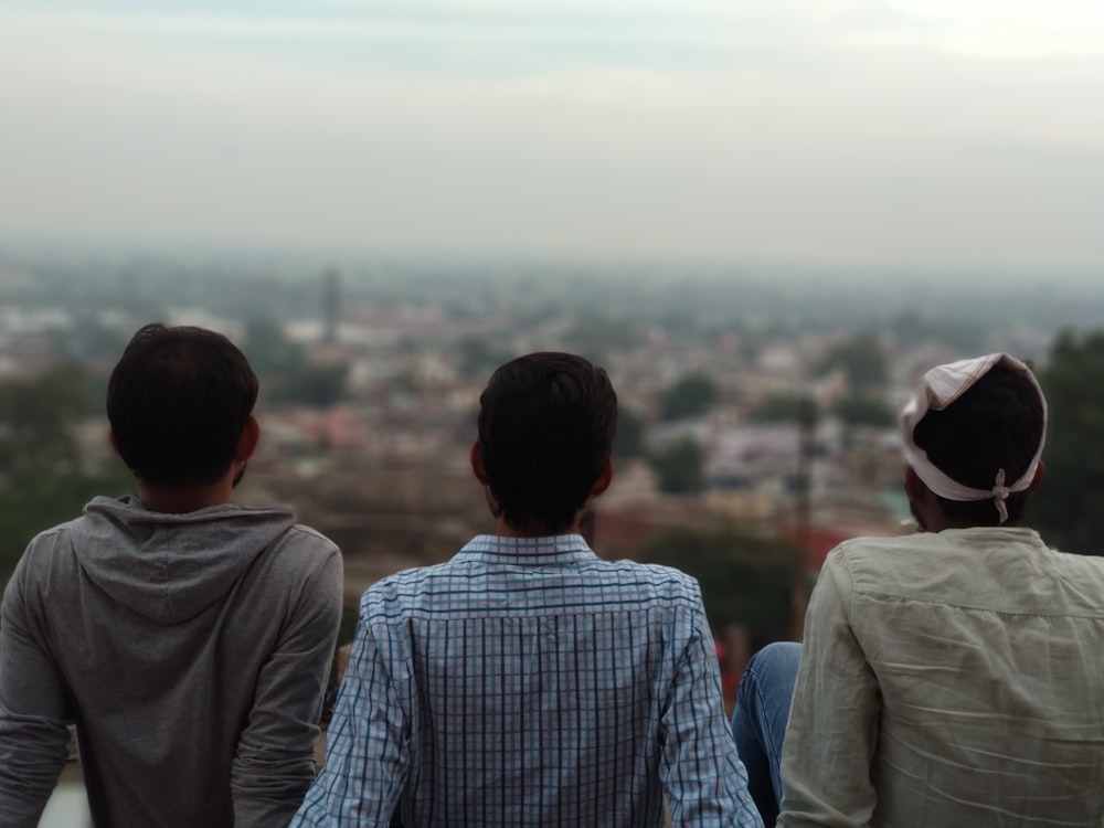 건물 꼭대기에 앉아있는 세 남자