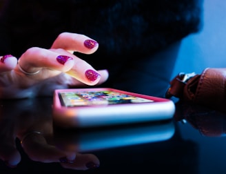 person using black smartphone with gray and pink case