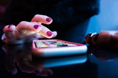 person using black smartphone with gray and pink case