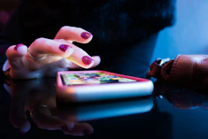 person using black smartphone with gray and pink case