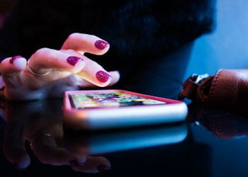 person using black smartphone with gray and pink case