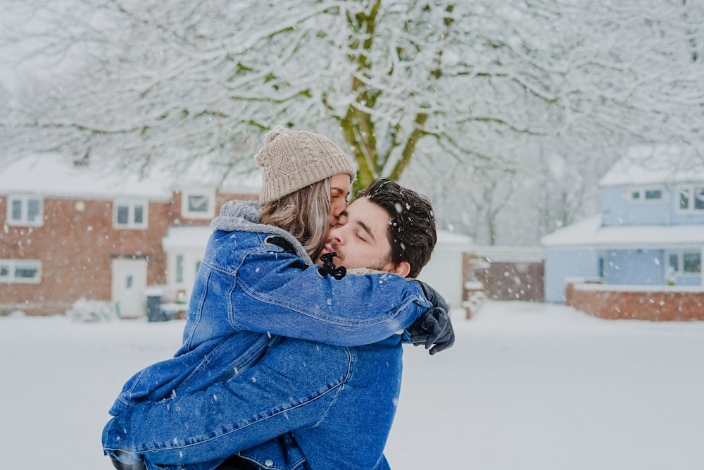 man and woman hugging on snow field