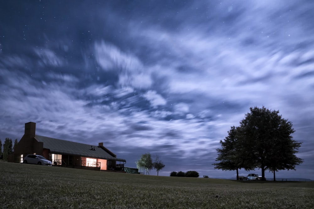 Haus in der Nähe von Bäumen und Autos während der Nacht