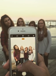 A group of diverse women in maritime gear smiling on a Chicago dock with boats behind them.