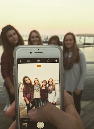 A group of diverse women in maritime gear smiling on a Chicago dock with boats behind them.