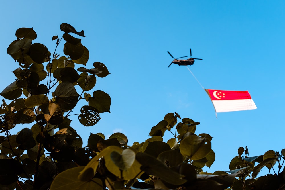 a helicopter flying over a flag in the air