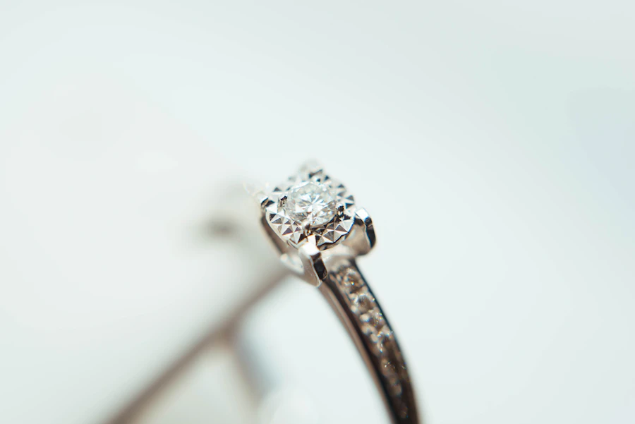 Solitaire diamond engagement ring with diamond-set shoulders