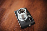 Soft-focus image of a vintage camera on a rustic wooden table.