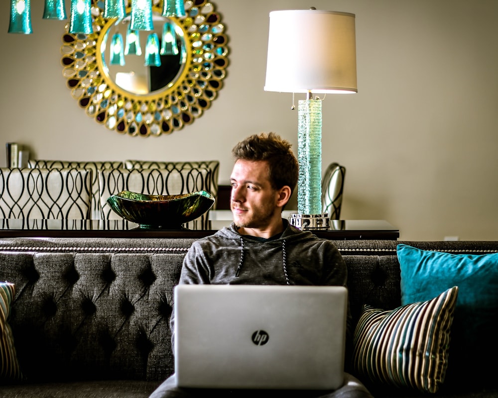 man looking aside with HP laptop on his lap