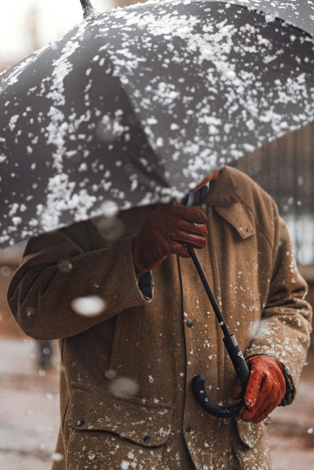 Ein Mann, der einen Regenschirm im Schnee hält