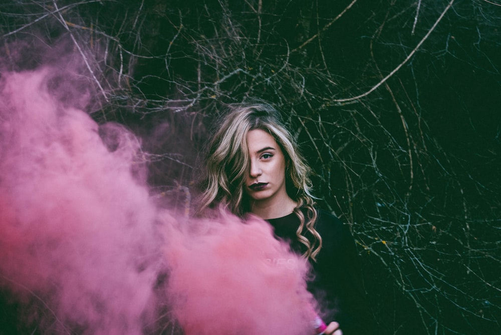 woman standing near pink smoke