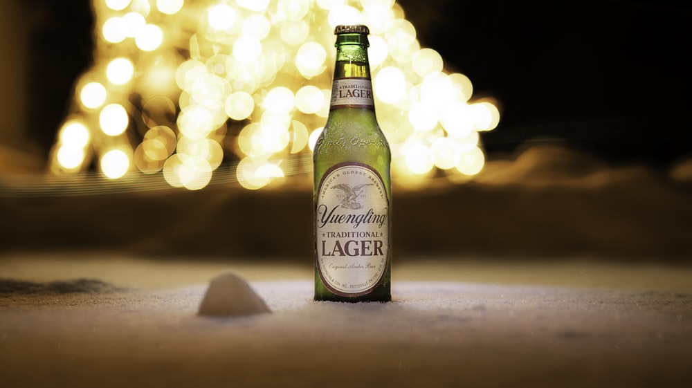 lager bottle on white sand beach