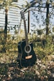 black acoustic guitar on green grass