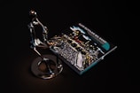 A sleek metallic sculpture of a person playing a saxophone is positioned beside a CD case featuring album art for 'Igor Butman Big Band.' The setting is dark, highlighting the reflective surface of the sculpture and the vibrant colors of the CD cover art.