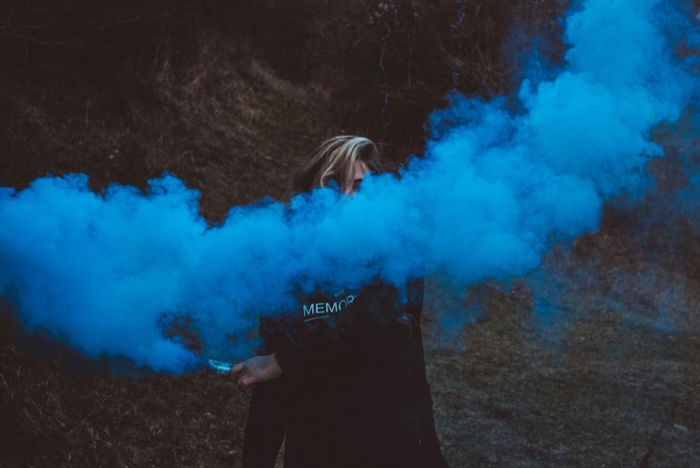 person holding blue smoke