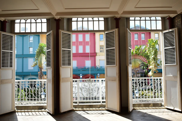 Bright bedroom with a large window overlooking a bustling Spanish city street