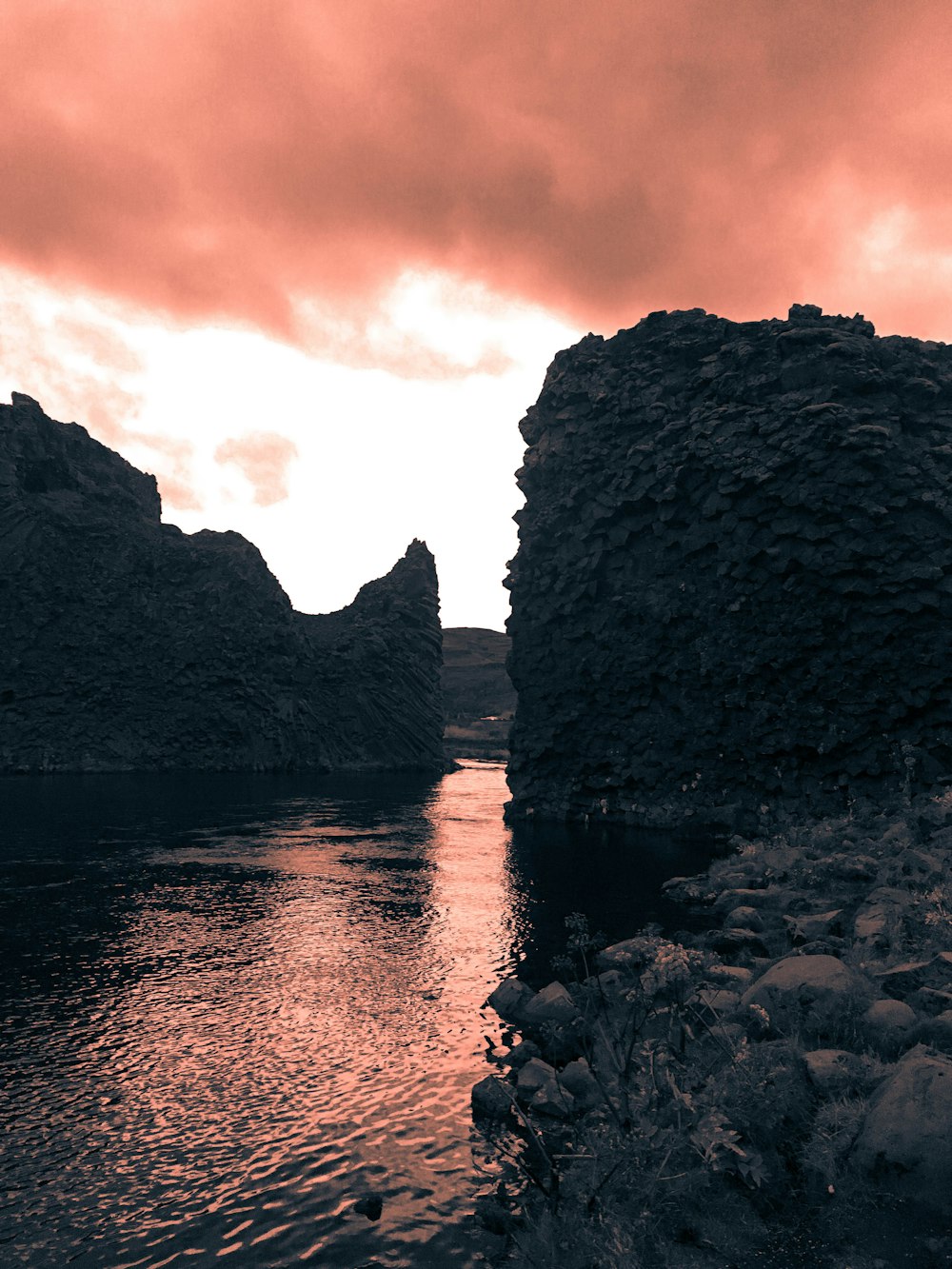 photo of body of water between cliff