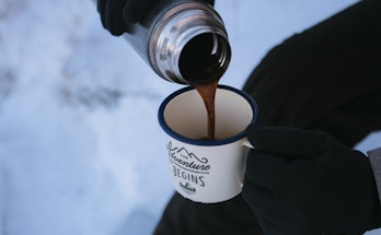 person pouring coffee in mug