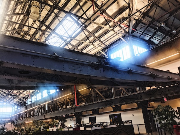 A sleek industrial workspace showing steel beams, design sketches, and logistics plans on a large table.