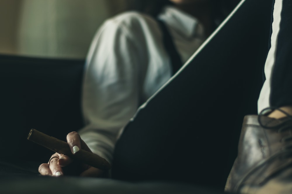 a person sitting on a couch holding a cigarette