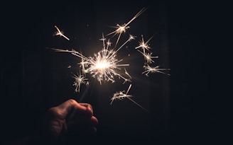 A close-up of hands releasing glowing particles into the air.