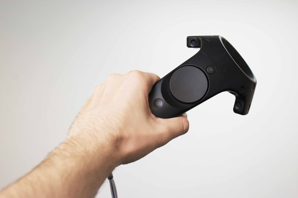 personne tenant une manette VR noire