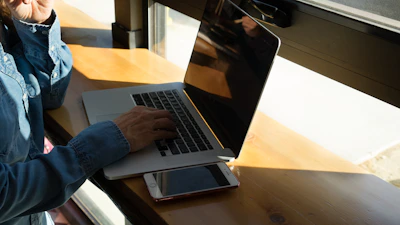 A professional using a laptop in a cozy, sunlit corner of the coworking space.