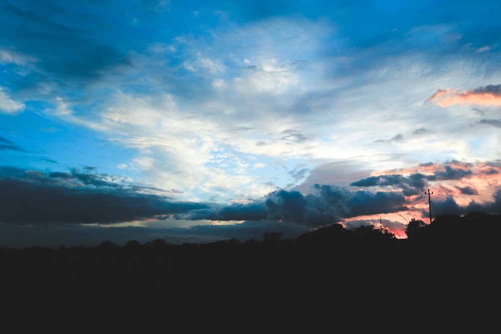 silhouette of mountain under gray clouds at golden hour