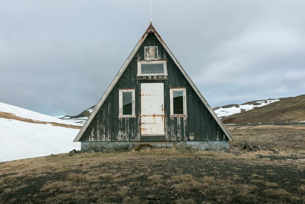 photo of black wooden house on mountain