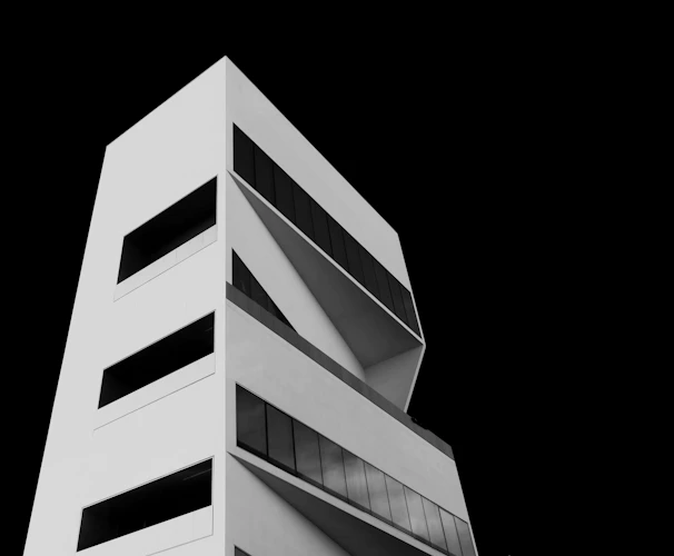High-contrast industrial building under construction with clean geometric lines and steel framework against a white background.