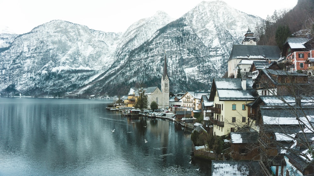 Weiße und braune Häuser an Gewässern und in der Nähe von schneebedeckten Bergen am Tag