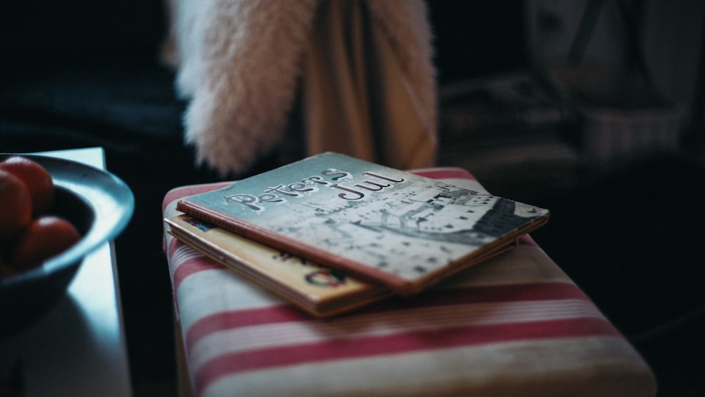 Zwei Bücher auf rotem Stuhl neben Tisch