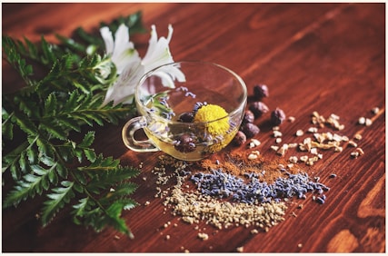 clear tea cup on brown surface