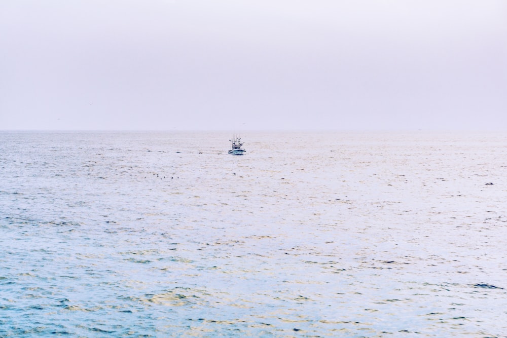 a small boat in the middle of a large body of water