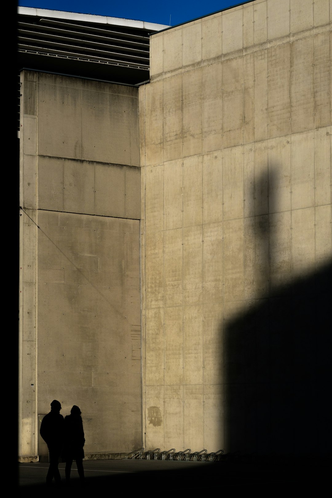 two silhouette of person standing near wall